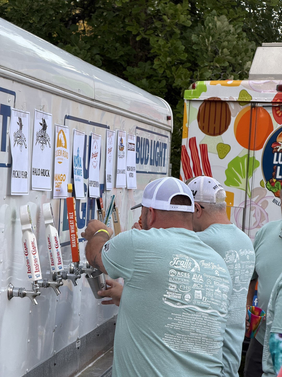 Guests pouring craft beer from the taps at Ales for Trails