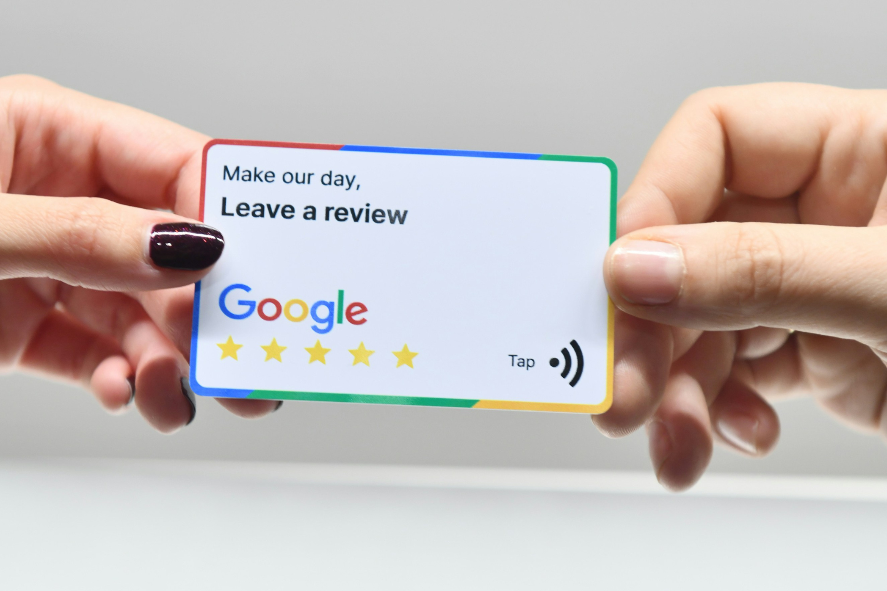 Photo of hands holding a card that reads "leave us a review, make our day"