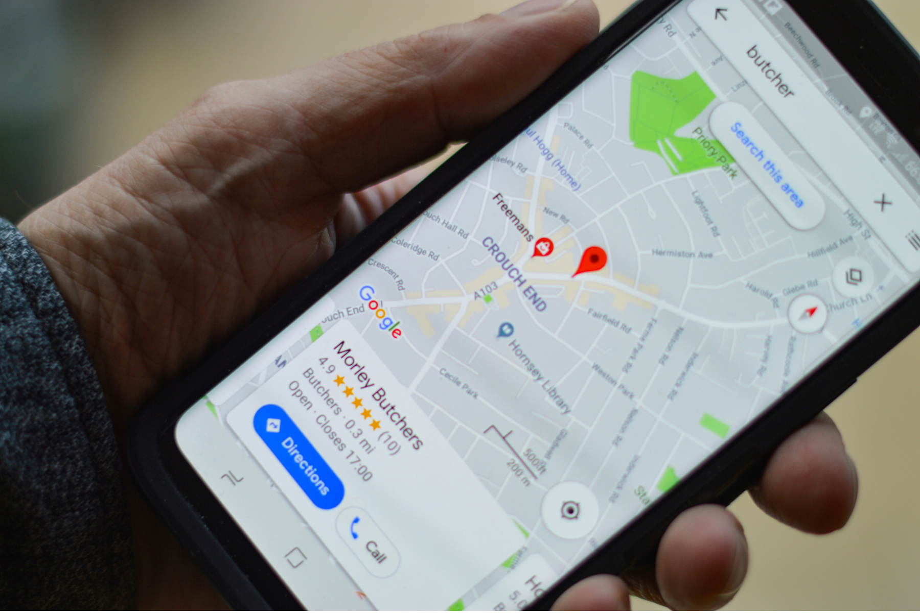 Photo of a phone with a Google Business profile on screen.