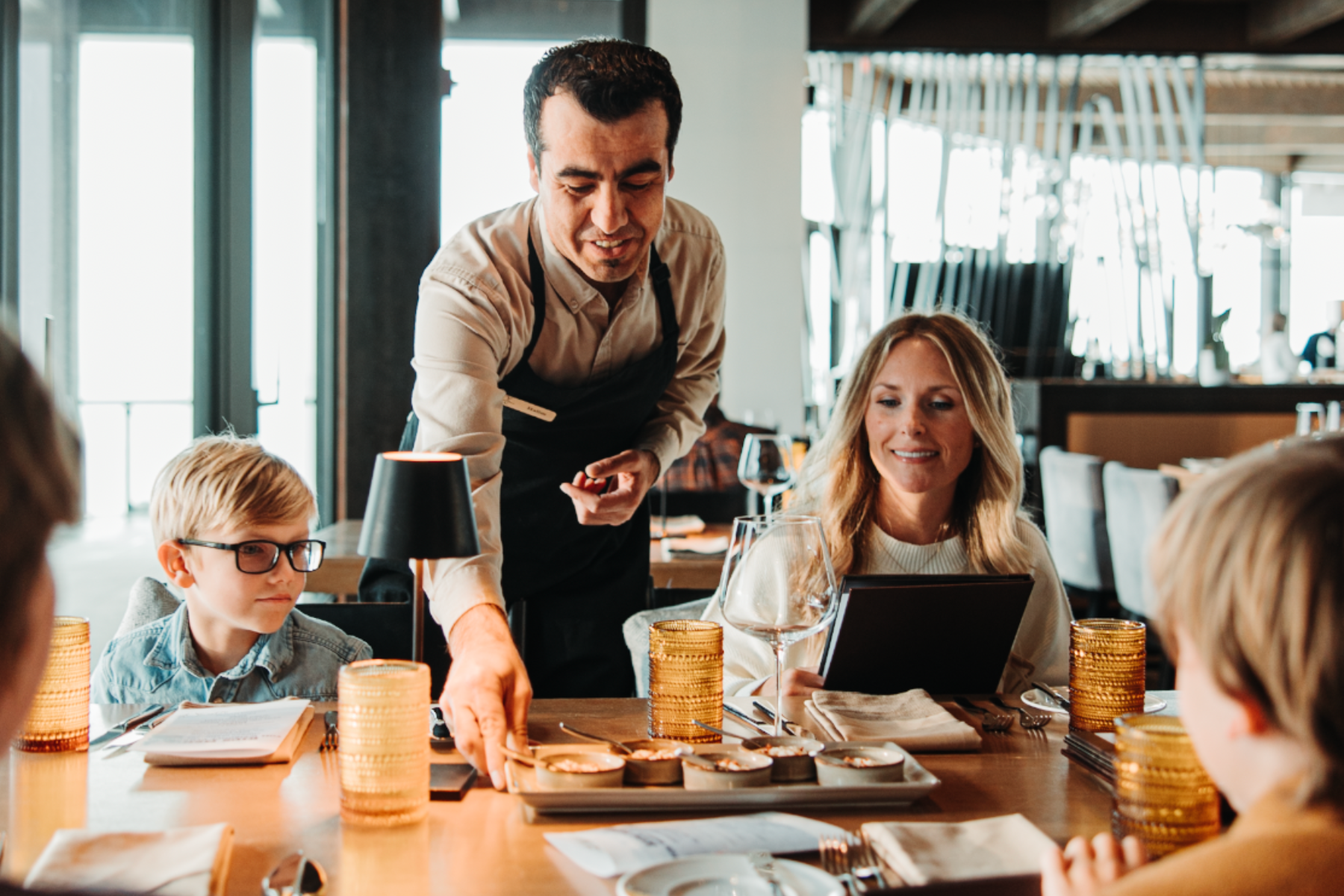 Photo of server at Yellowstone Club delivering food to a family