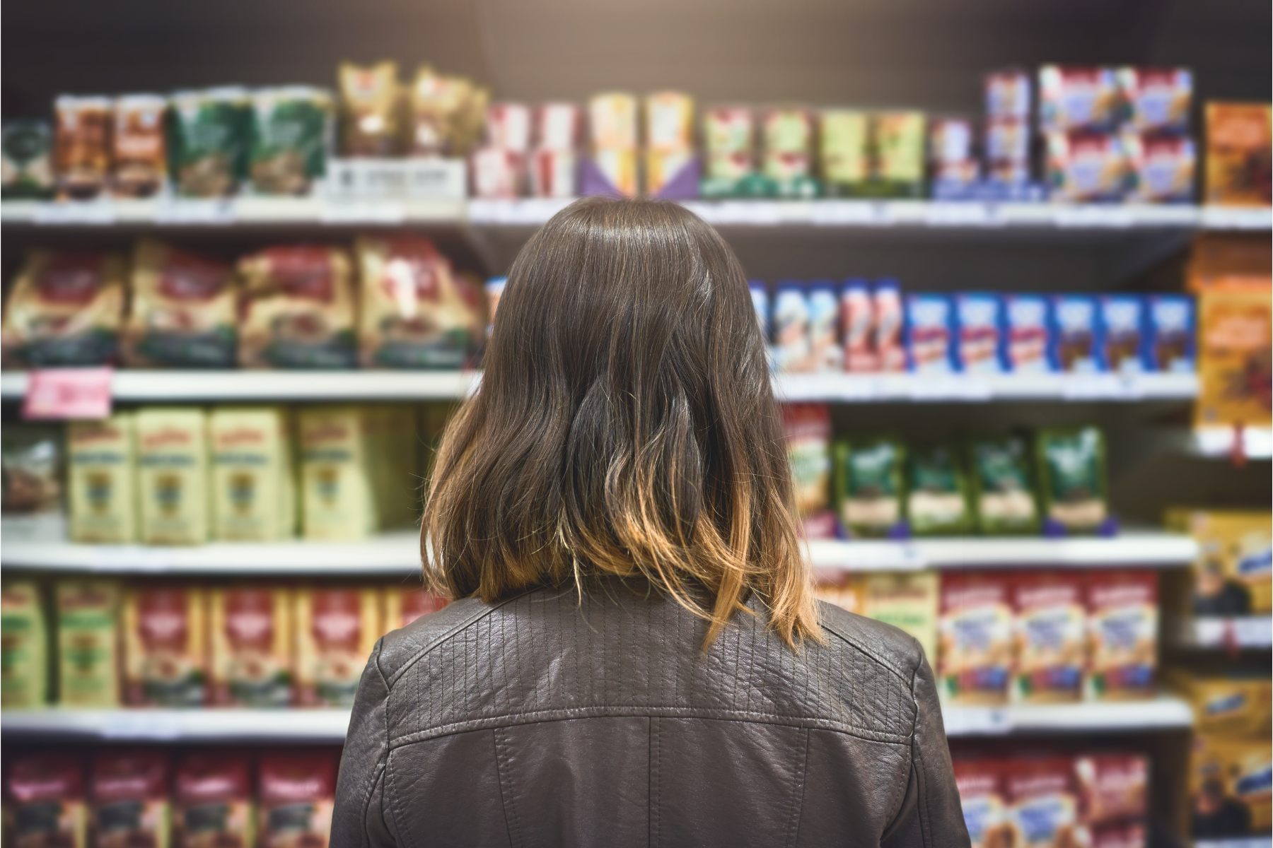 Photo of a woman standing in front of a grocery store shelf