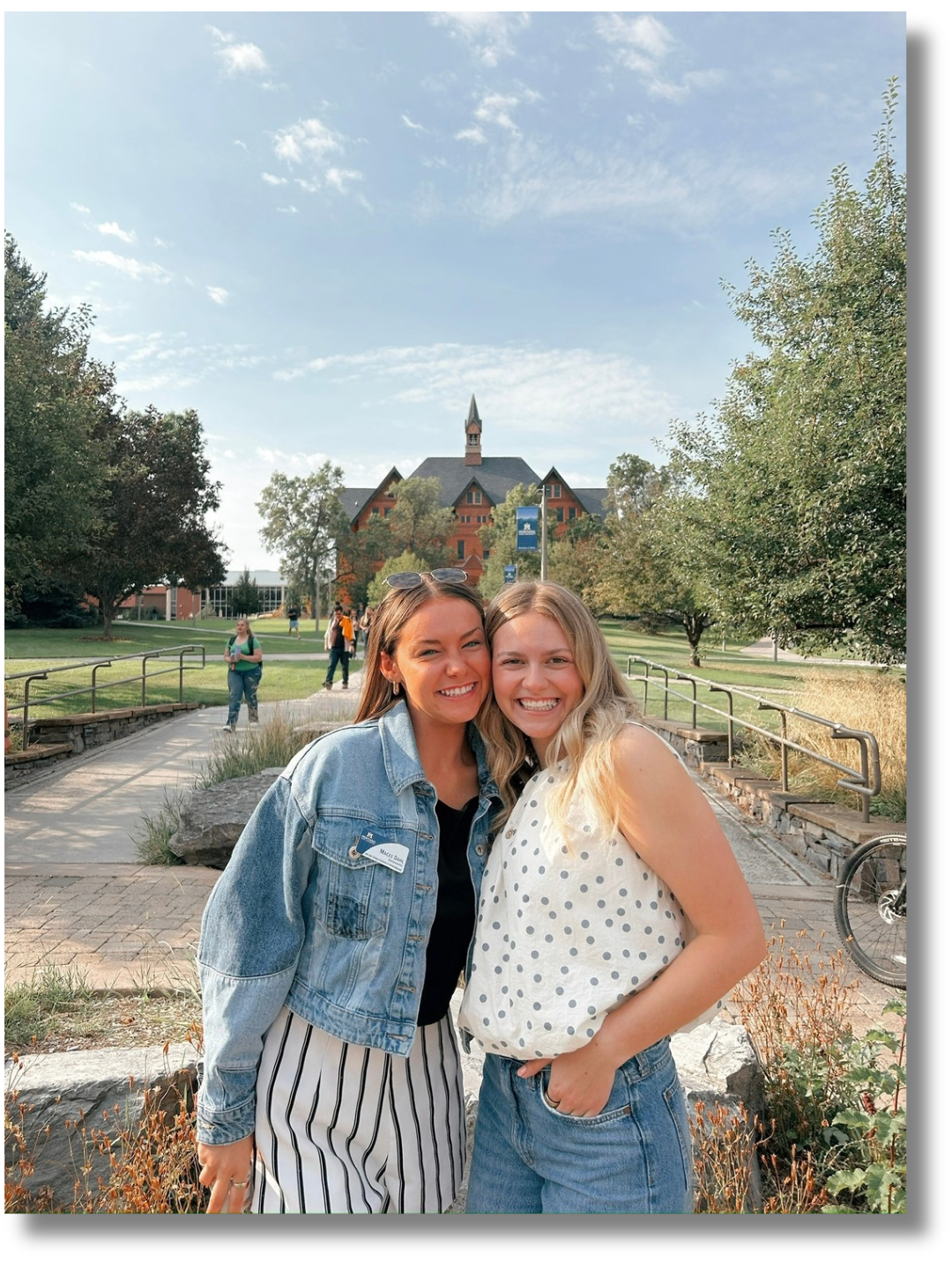 Two friends posing on a college campus in the fall
